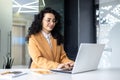 Portrait of mature successful businesswoman at workplace inside office, Hispanic woman with curly hair happily working Royalty Free Stock Photo