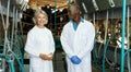 Two workers near milking line Royalty Free Stock Photo