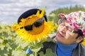 Portrait of mature woman with her friend big sunflower in sunglasses against the sky Royalty Free Stock Photo