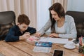 Portrait of a mature woman spending time with her son painting together for a school project , very attractive people in Royalty Free Stock Photo