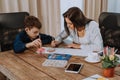 Portrait of a mature woman spending time with her son painting together for a school project , very attractive people in Royalty Free Stock Photo