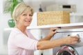 portrait mature woman using washing machine Royalty Free Stock Photo