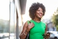 Portrait of smiling woman with mobile phone in the city Royalty Free Stock Photo