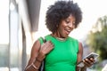 Portrait of smiling woman with mobile phone in the city Royalty Free Stock Photo