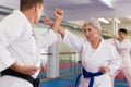 Portrait of woman wearing white kimono sparring with male opponent during martial arts training Royalty Free Stock Photo