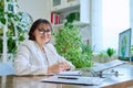 Portrait of mature woman working at home on computer laptop Royalty Free Stock Photo