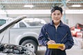 portrait mechanic engineer male happy for service fix repair broken car in garage auto shop. car insurance claim cost estimate