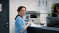 Portrait of medical assistant talking to receptionist at hospital reception counter Royalty Free Stock Photo