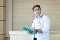 Portrait medical male doctor wear white coat hanging stethoscope taking notes writing on clipboard profession standing in hospital
