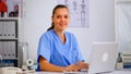 Portrait medical nurse in blue practitioner uniform smiling at camera