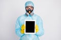Portrait of medical worker man present tablet wear biohazard uniform breathing mask isolated over gray color background Royalty Free Stock Photo