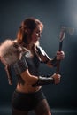 Portrait of a medieval, fantasy viking woman with an ax in her hands in the dark. Royalty Free Stock Photo