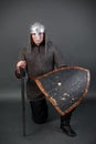 Portrait of a medieval warrior of the late viking era and the beginning of the crusades sitting on his knee. Knight in chain mail Royalty Free Stock Photo