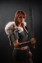 Portrait of a medieval woman warrior in chain mail armor and polar fox fur on her shoulders standing with a sword in hand Royalty Free Stock Photo