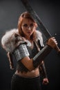 Portrait of a medieval woman warrior in chain mail armor and polar fox fur on her shoulders standing with a sword in hand Royalty Free Stock Photo