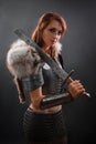 Portrait of a medieval woman warrior in chain mail armor and polar fox fur on her shoulders standing with a sword in hand Royalty Free Stock Photo