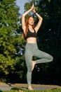 Portrait of meditative redhead young woman doing yoga in tree pose, raising hands in Namaste pose Royalty Free Stock Photo