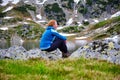 Portrait of a melancholic woman hiker at mountain lake Bucura, in Retezat mountains part of Carpathians, Romania.