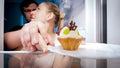 Portrait of young man stopping his wife that looking for something to eat in refrigerator Royalty Free Stock Photo