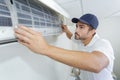 Portrait mid-adult male technician repairing air conditioner Royalty Free Stock Photo