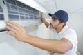 Portrait mid-adult male technician repairing air conditioner Royalty Free Stock Photo
