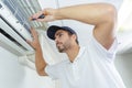 Portrait mid-adult male technician repairing air conditioner Royalty Free Stock Photo