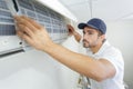 Portrait mid-adult male technician repairing air conditioner Royalty Free Stock Photo