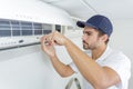 Portrait mid-adult male technician repairing air conditioner Royalty Free Stock Photo