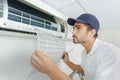 Portrait mid-adult male technician repairing air conditioner Royalty Free Stock Photo