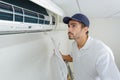 Portrait mid-adult male technician repairing air conditioner