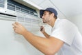 Portrait mid-adult male technician repairing air conditioner Royalty Free Stock Photo