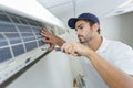 Portrait mid-adult male technician repairing air conditioner Royalty Free Stock Photo