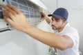 Portrait mid-adult male technician repairing air conditioner Royalty Free Stock Photo