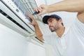 Portrait mid-adult male technician repairing air conditioner Royalty Free Stock Photo