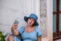 Portrait mid adult pregnant woman takes selfie, Travel pregnancy concept. Social media trip