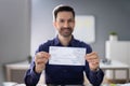 Smiling Businessman Holding Cheque