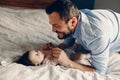 Caucasian father talking to newborn baby son daughter. Male man parent smiling to child