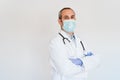 Portrait of middle age doctor wearing protective mask and gloves indoors. Corona virus concept Royalty Free Stock Photo