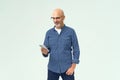 Portrait of middle aged bald handsome man holding smartphone in hand interested look of reading text or browsing social Royalty Free Stock Photo