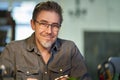 Portrait of middle aged bearded guy at home. maturee handsome man smiling, looking at camera, working at home, using laptop Royalty Free Stock Photo