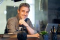 Portrait of middle aged bearded guy at home. Older handsome man smiling, looking at camera, working at home, using laptop computer