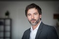 A portrait of a middle-aged bearded serious man looking at the camera isolated on a gray background Royalty Free Stock Photo