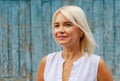 Portrait of a middle-aged beautiful cheerful woman on a wooden wall background. Success, antiaging Royalty Free Stock Photo