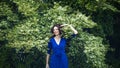 Portrait of a middle-aged brunette in a blue dress next to a blooming linden Royalty Free Stock Photo