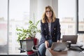 Portrait of middle aged buisnesswoman using laptop and headphone while working at the office Royalty Free Stock Photo