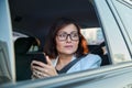 Portrait of middle-aged business woman in car in back passenger seat. Royalty Free Stock Photo