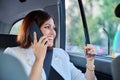 Portrait of middle-aged business woman in car in back passenger seat talking on phone. Royalty Free Stock Photo