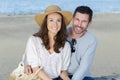 portrait middle-aged couple sitting on wall by beach Royalty Free Stock Photo