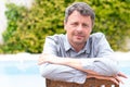 Portrait of middle aged man caucasian smiling and looking at camera outside at home house garden pool background Royalty Free Stock Photo