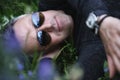 Portrait of middle-aged man lying on field among blue flowers. Pensive calm man in profile over nature outdoor Royalty Free Stock Photo